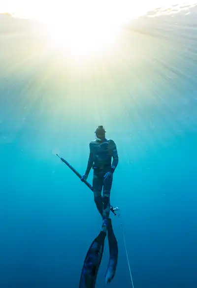 Spearfisher surfacing into sunlight