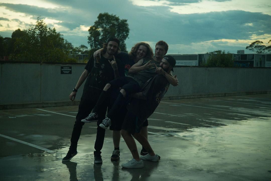 Four band members smiling at the camera