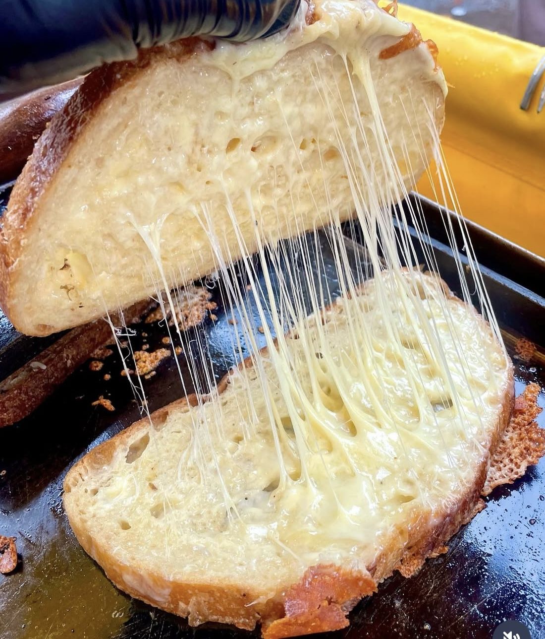 Grilled cheese TOASTIE being pulled apart with cheese strands