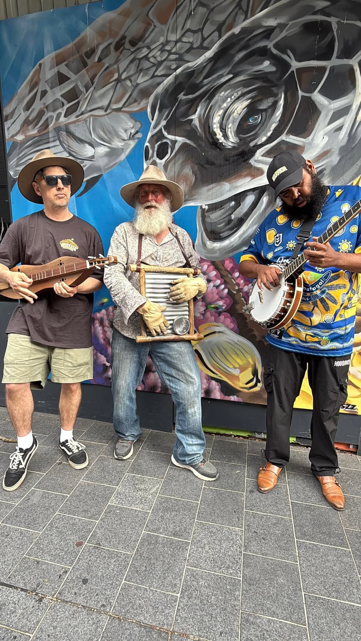 The Bush Billies standing in front of turtle image  background