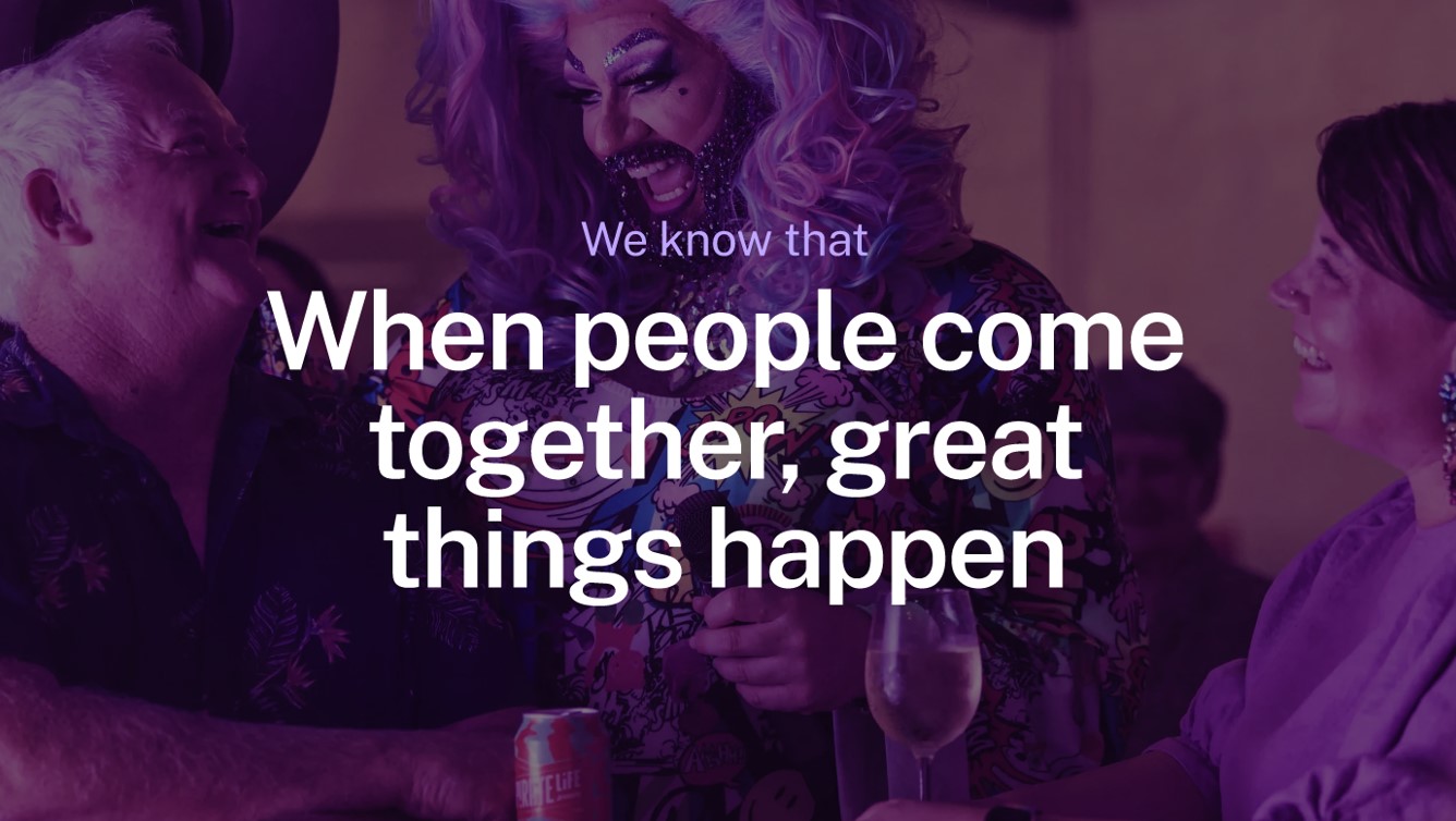 Drag performer with vibrant makeup and wig interacts with smiling people at a social gathering. Text overlay: "When people come together, great things happen."