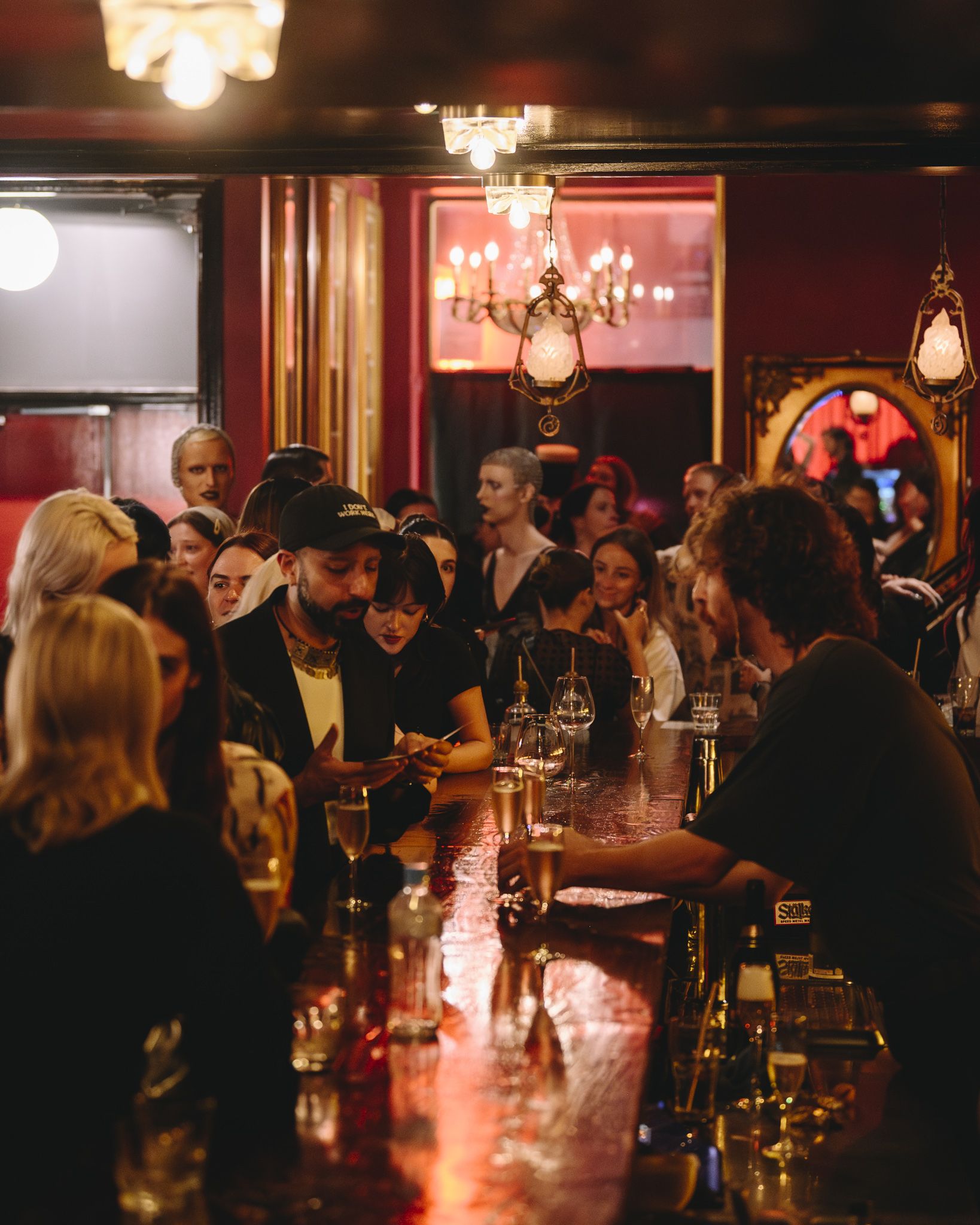 A group of people chatting and engaging by a moody bar