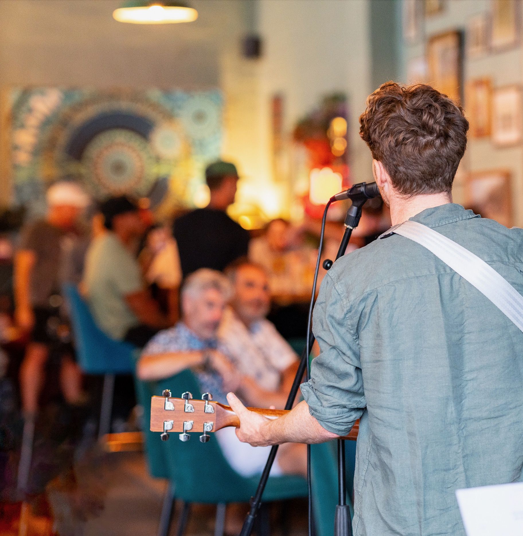 A singer-guitarist performing at the Good Bar