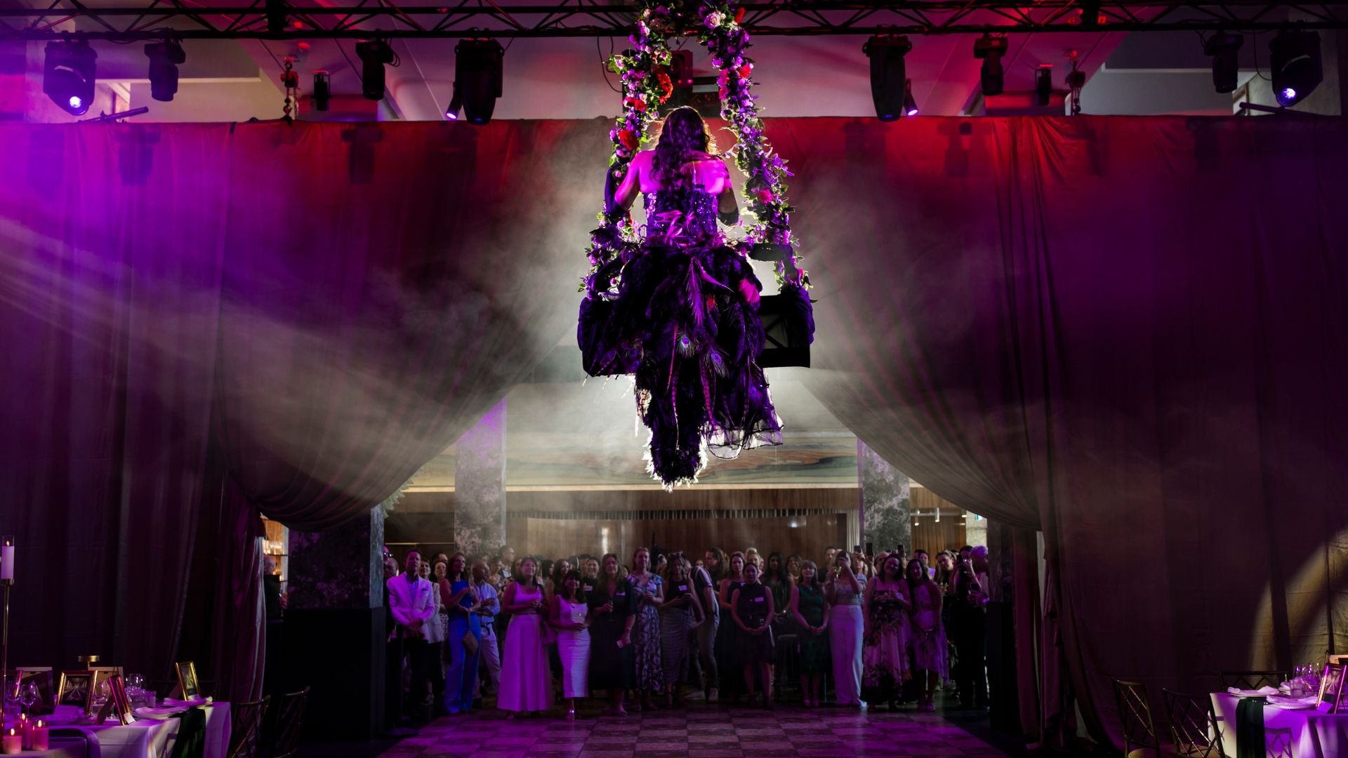 An aerial performer from behind, with the crowd in the background