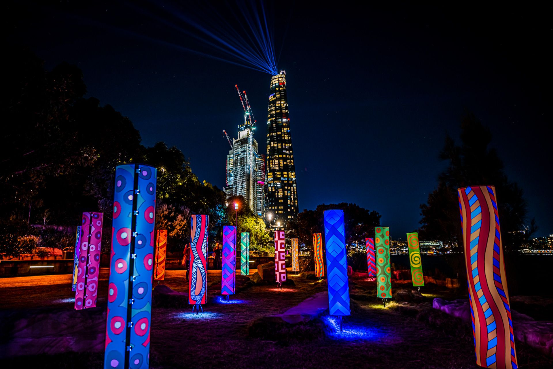 Illuminated pillars of First Nations artworks in vibrant colours