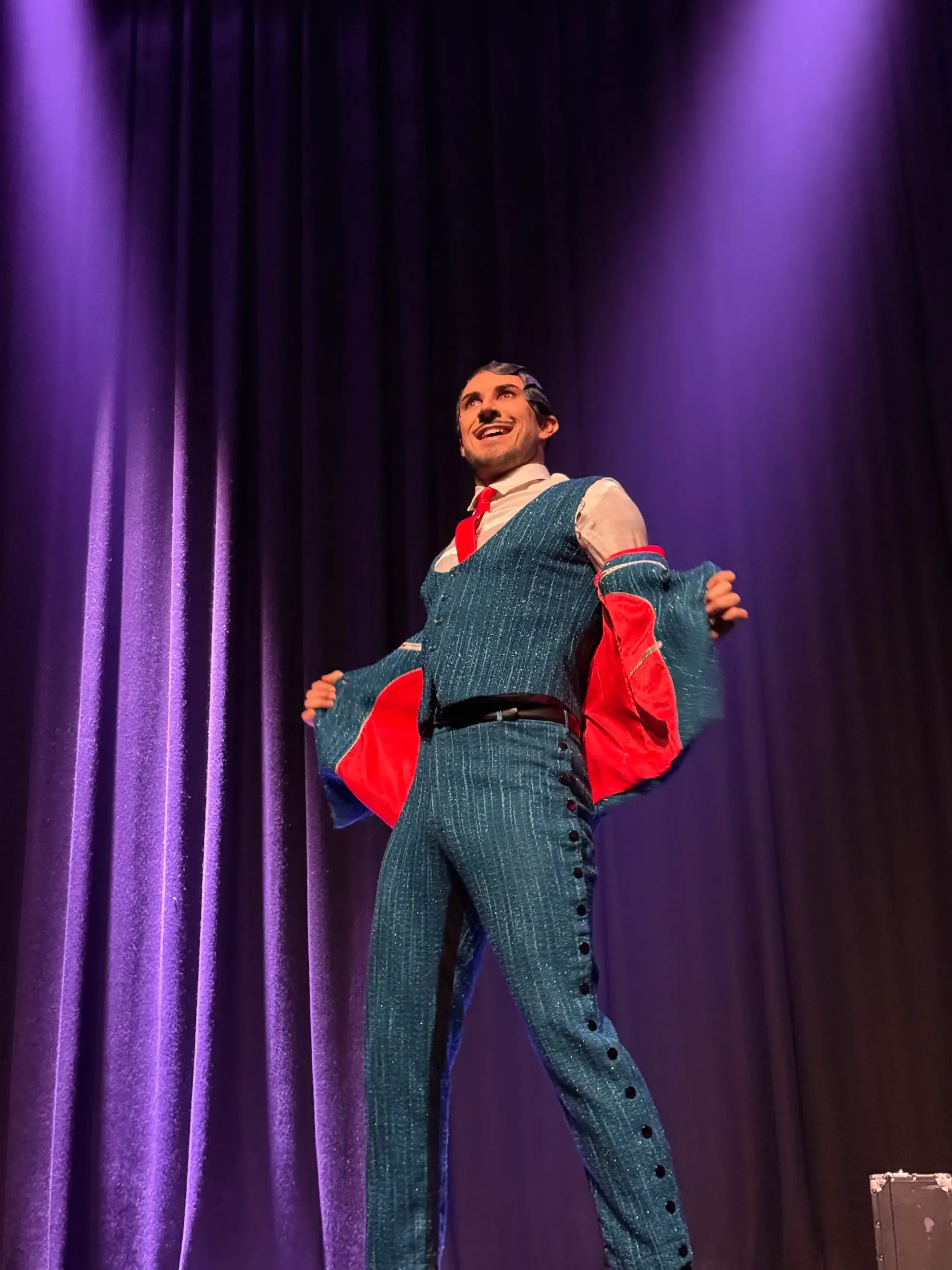 Rhys Lightning peels open his jacket of a smart yet sparkly blue suit