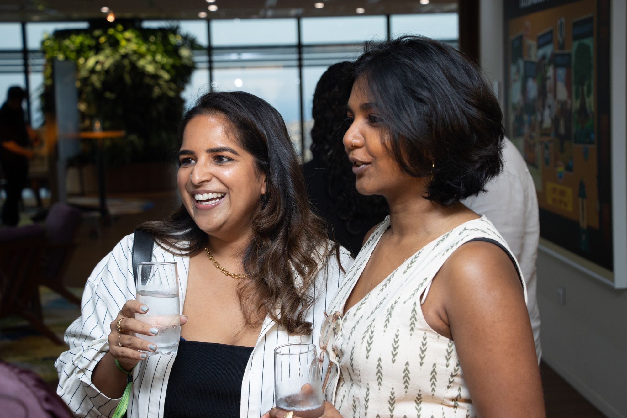 Two professionals posing together at an event, smiling at the camera
