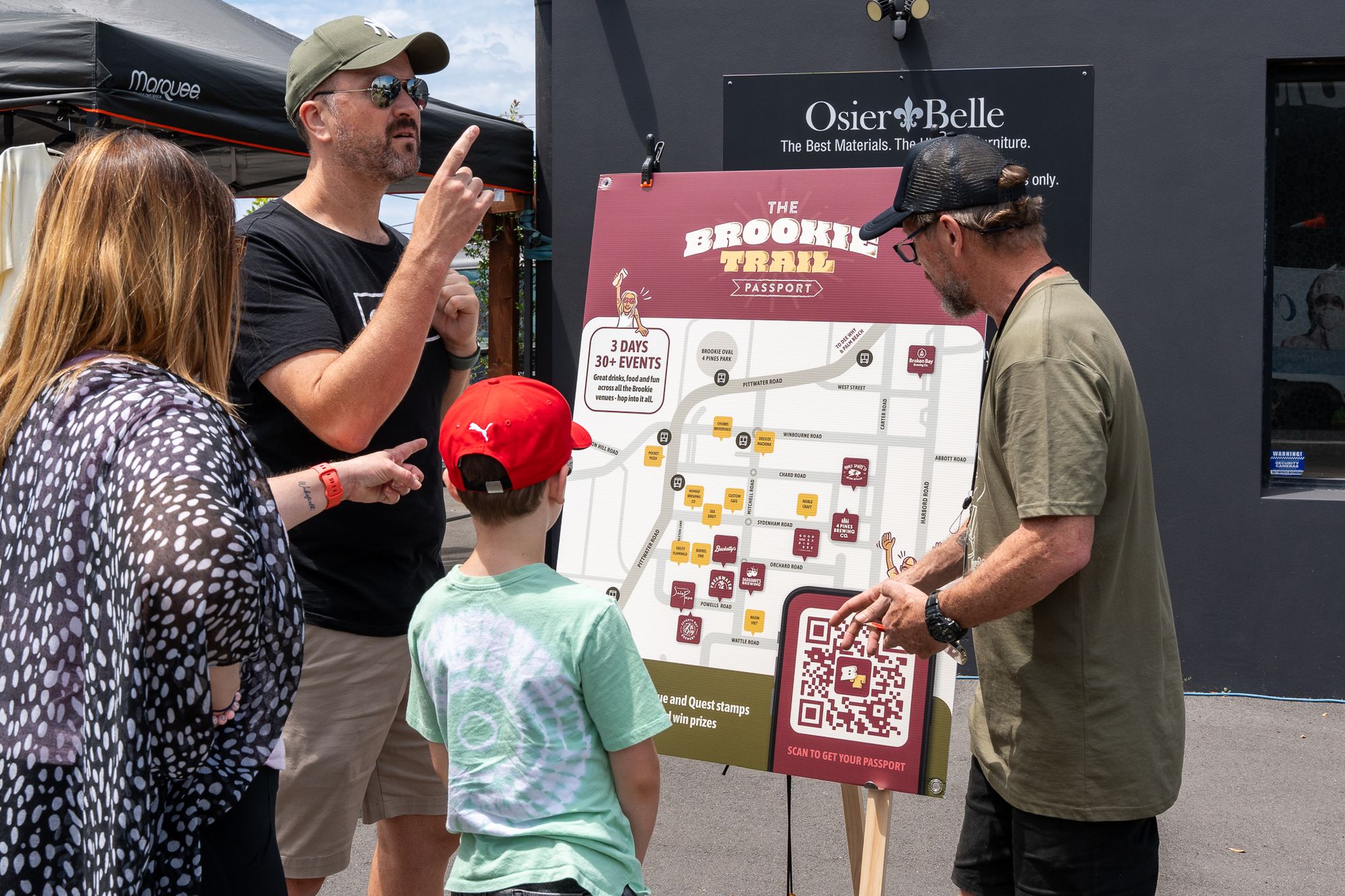 A Hoppy Trails staff member helps people Brookiefest attendees at the info tent