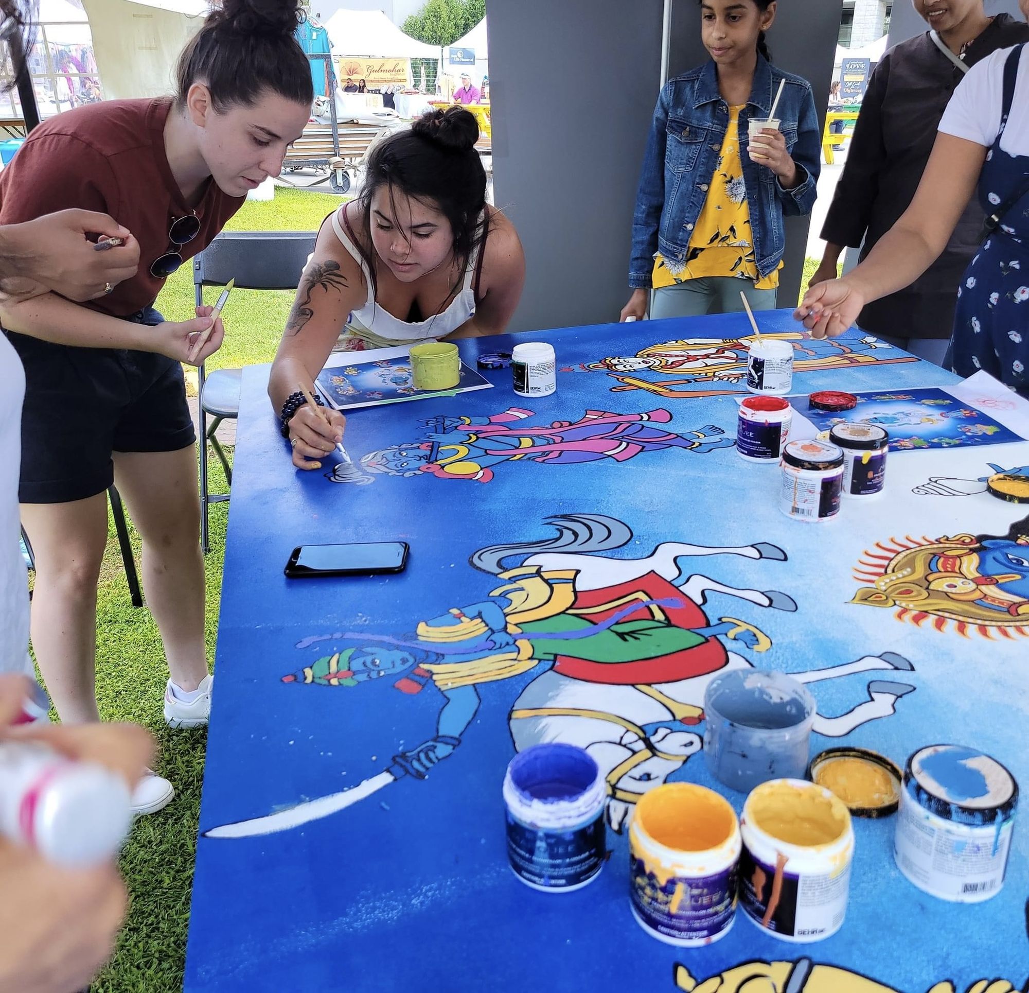 Painting a collaborative mural with the community at the Great Indian Festival