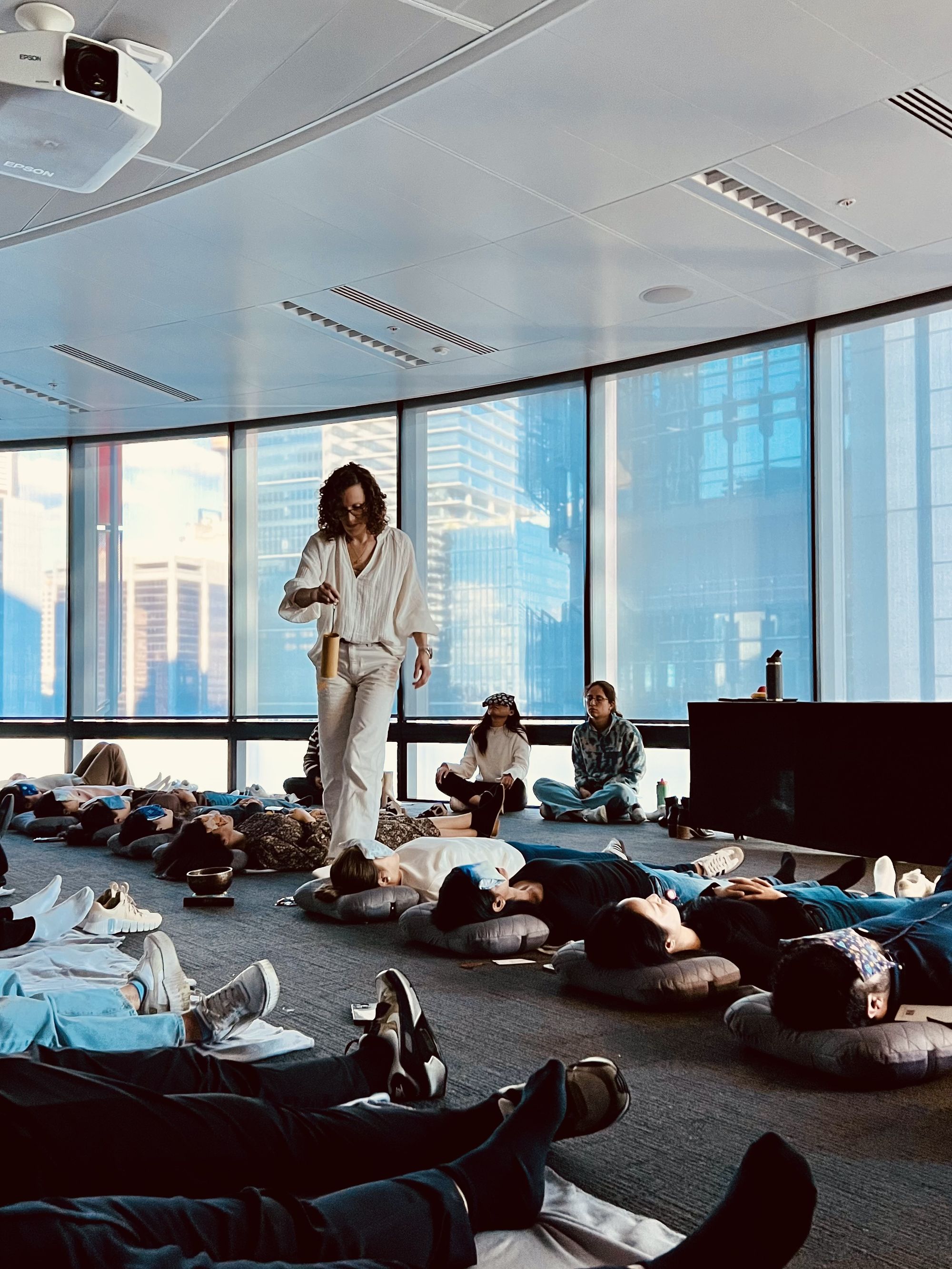 Yifat playing at a sound bath in a corporate setting