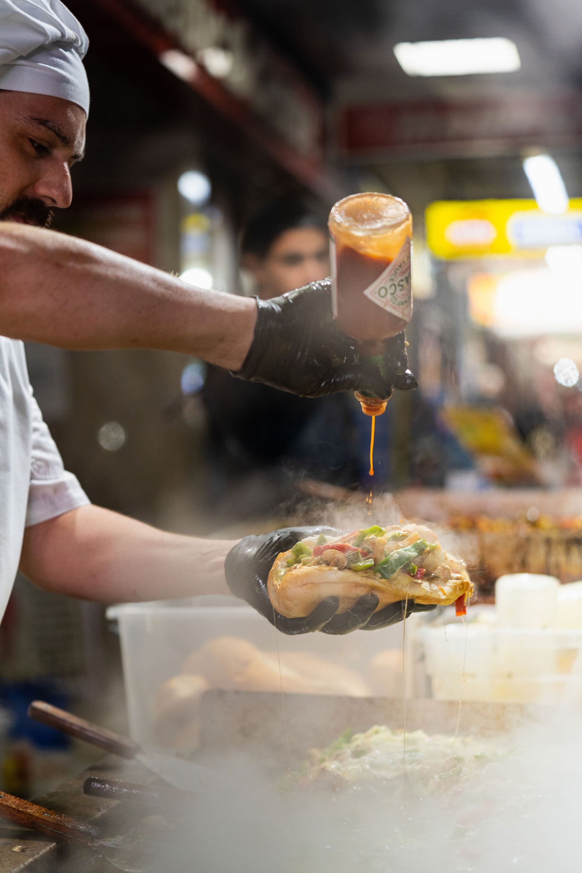 A man puts sauce on a roll