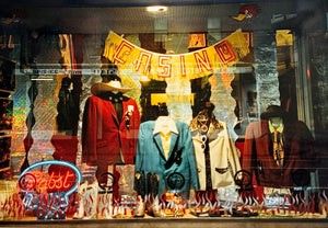 Storefront display with vintage clothing: red, blue, and white blazers. Neon "Open" sign and "Casino" banner above. Reflections visible.