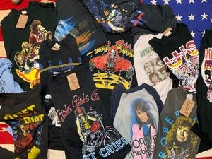 A collection of vintage band t-shirts featuring various rock and pop artists, displayed on a patterned backdrop.