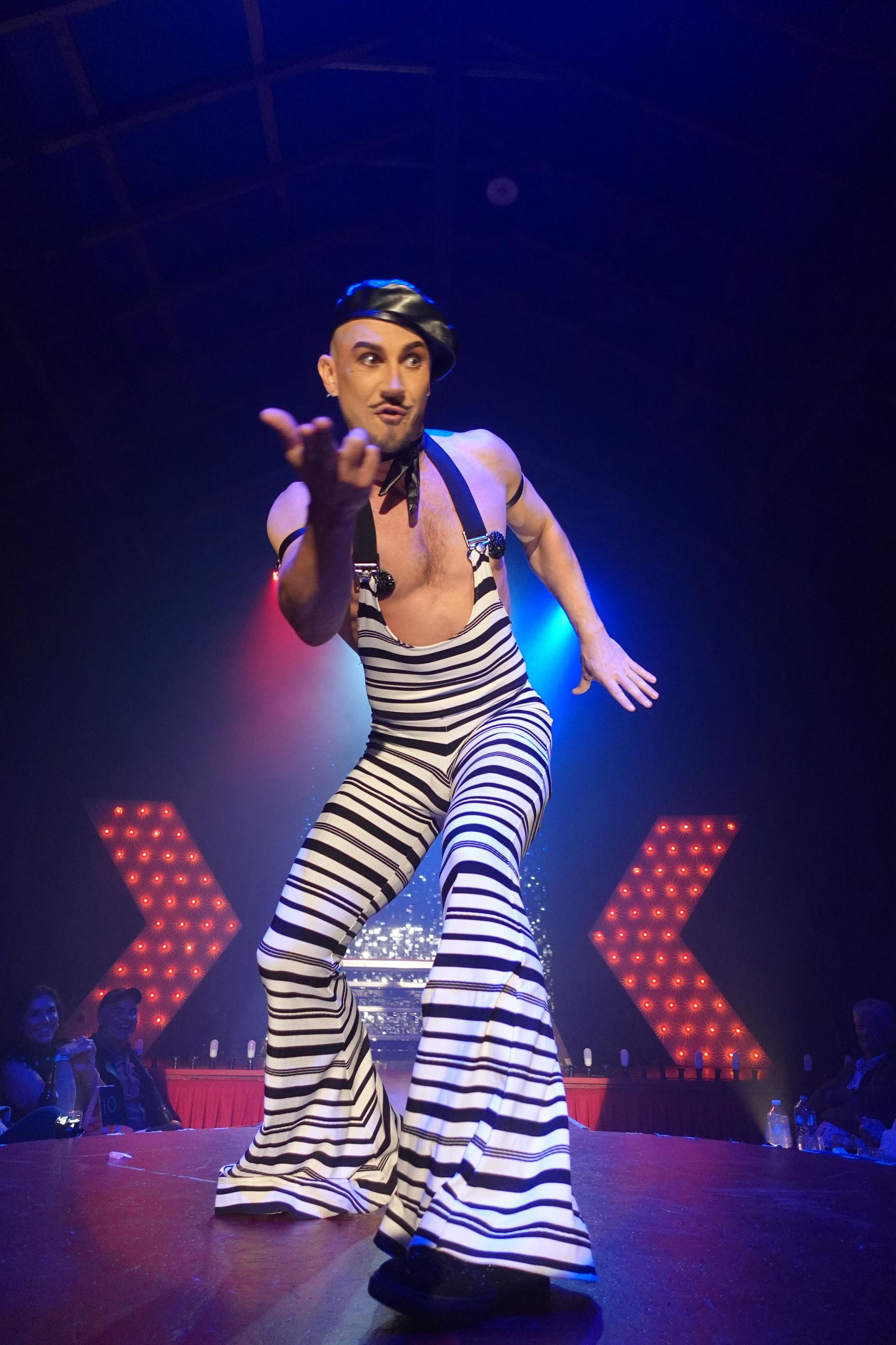 Rhys interacts with the crowd wearing a French themed black and white jumpsuit