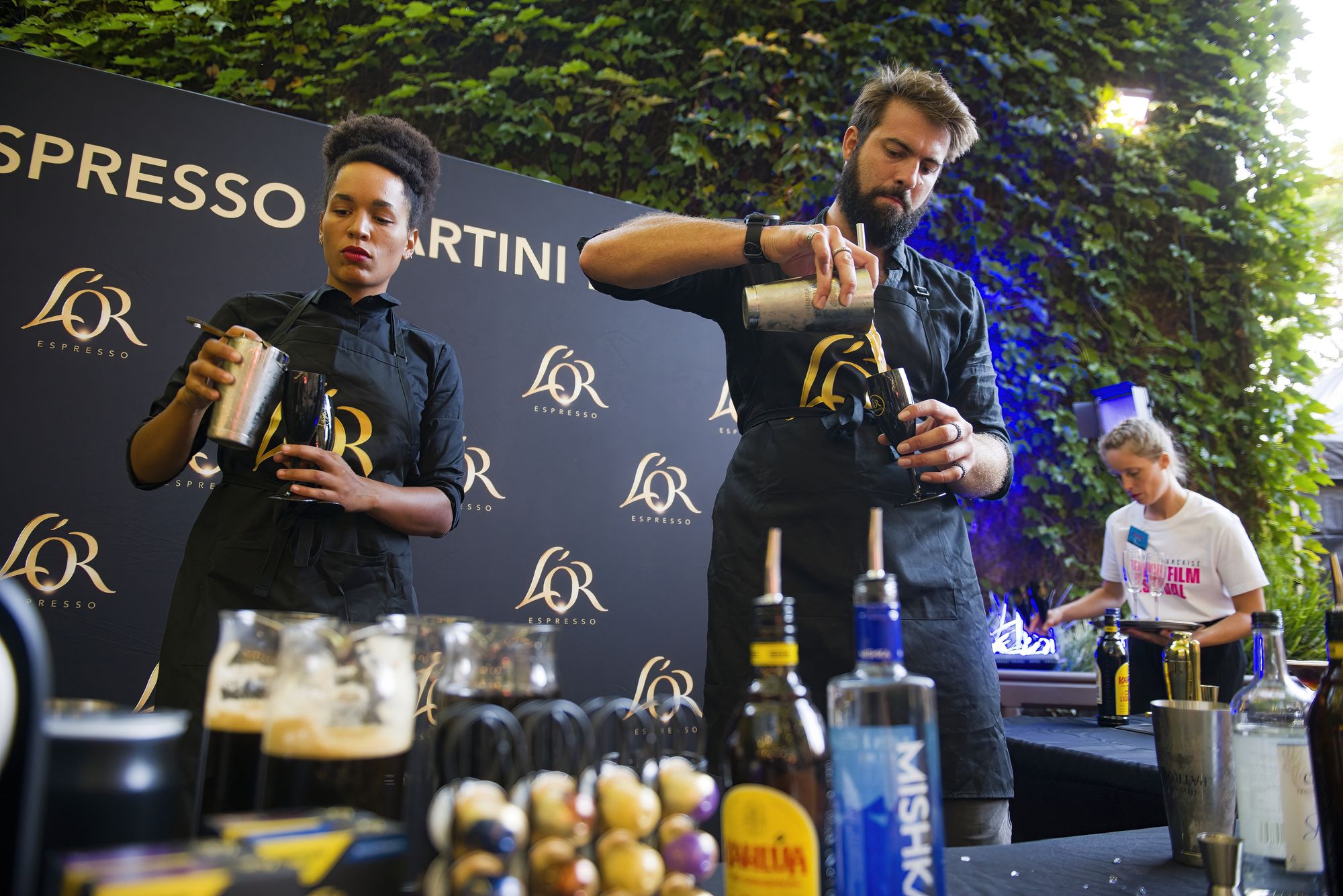 Two bartenders mixing cocktails