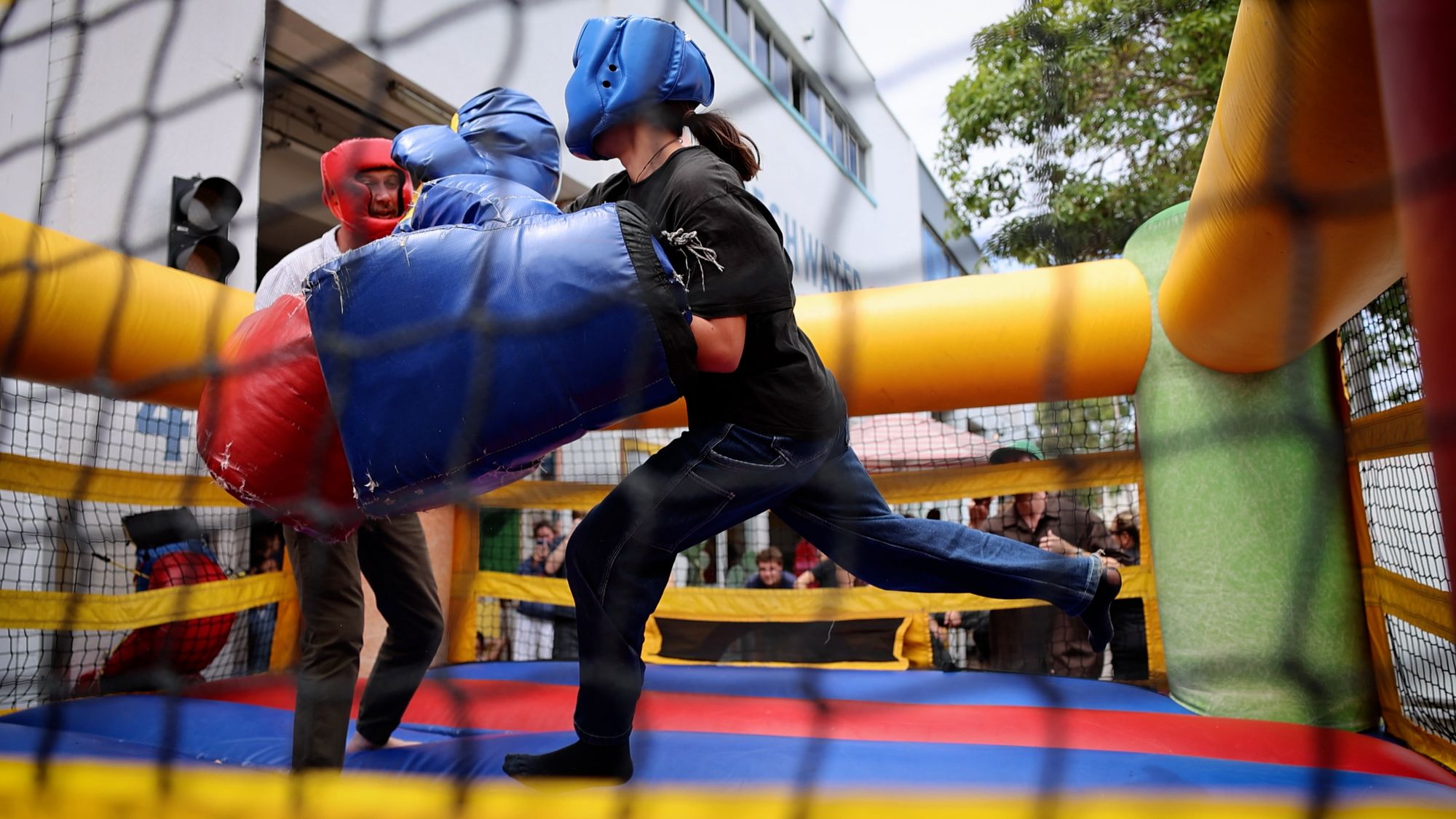 Two people boxing in an inflatable vovelty boxing rox.