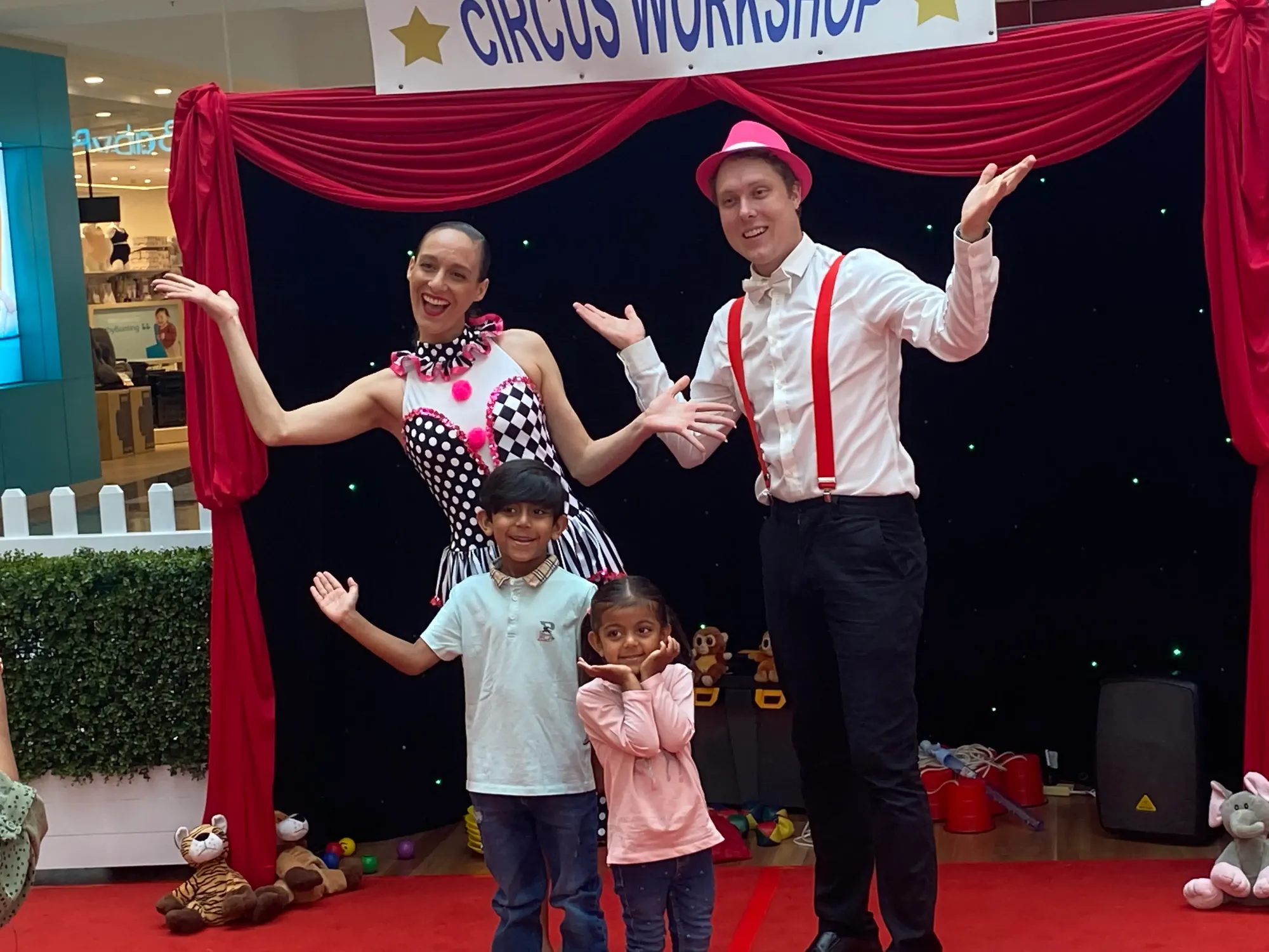 Circus entertainers posing with children after an interactive circus activity