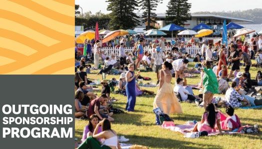 A vibrant outdoor festival with people relaxing on the grass under colorful umbrellas, trees in the background. Text reads "Outgoing Sponsorship Program."