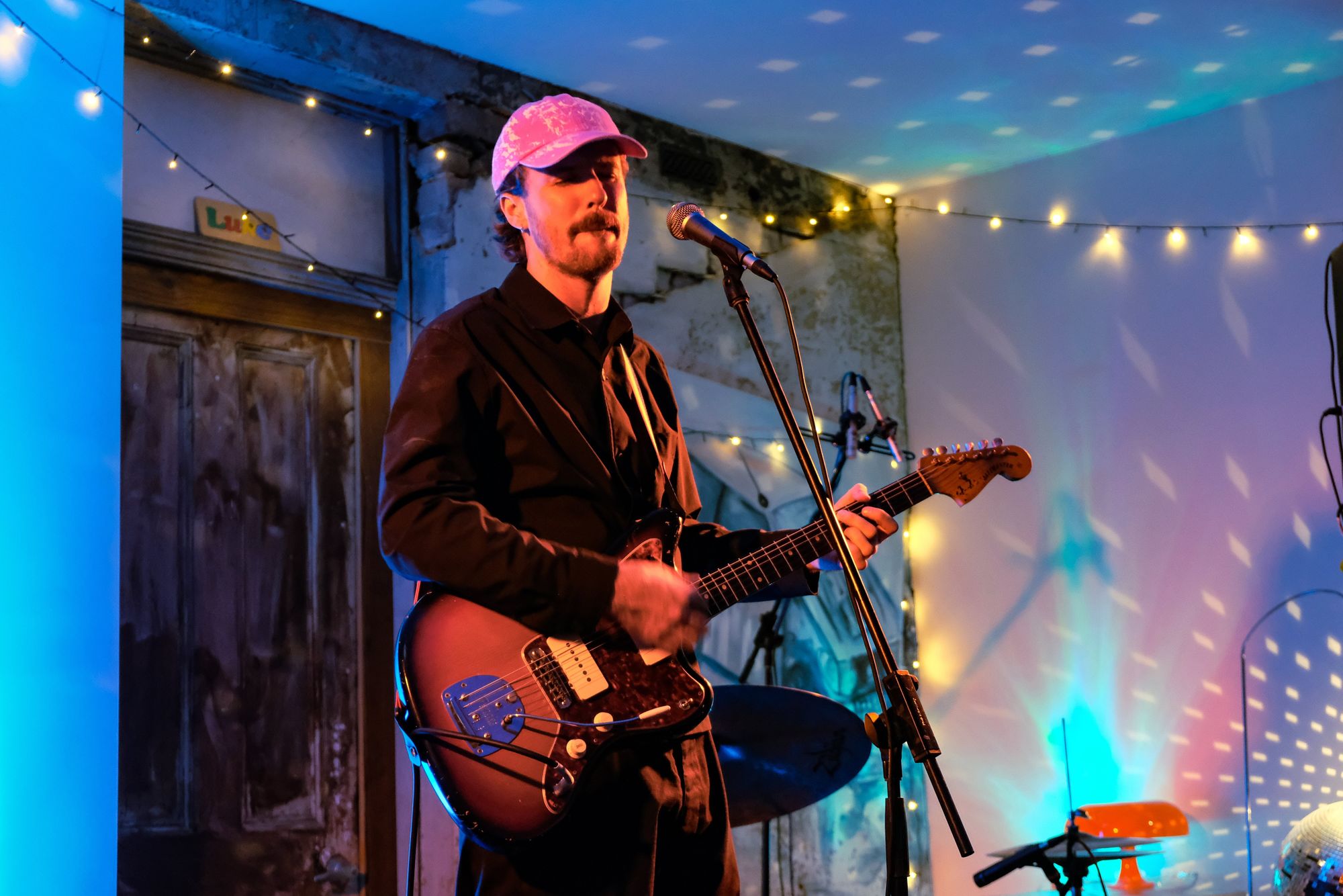 Male performer with eyes closed and guitar in hands lost in the moment of musical flight
