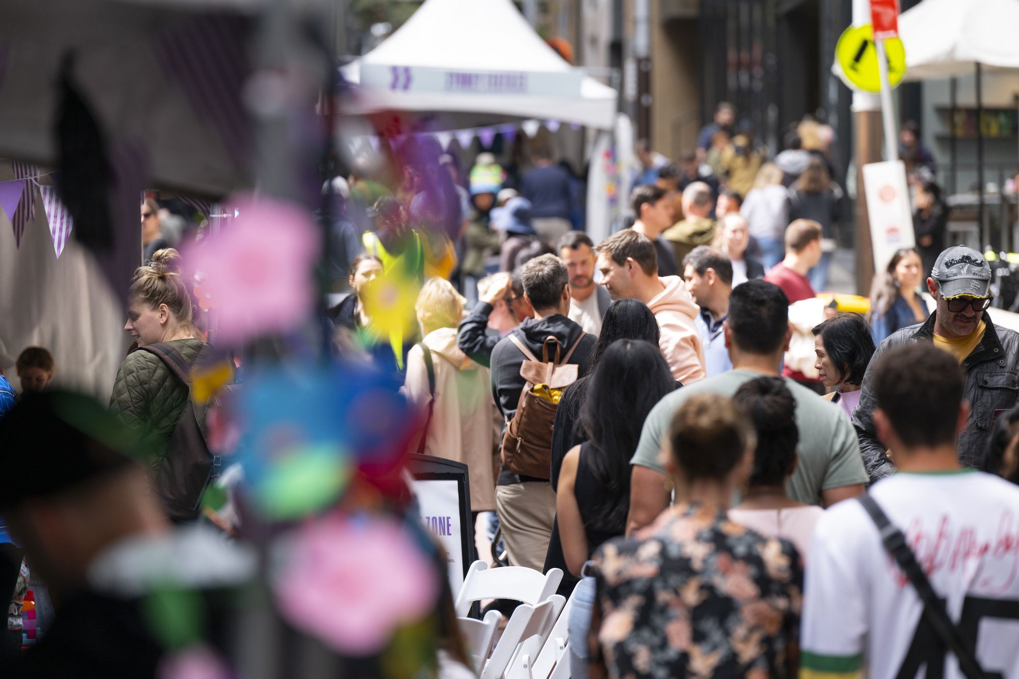 People walking in a pedestrian-friendly street looking at stalls