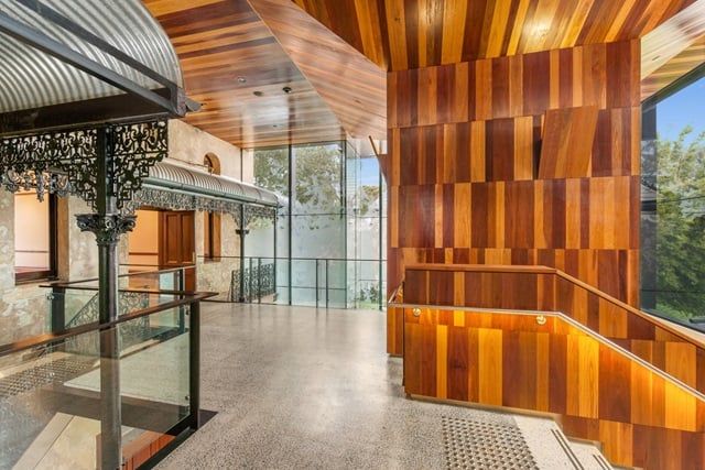 Indoor modern mezzanine space with wooden panelled walls and polished concrete floors