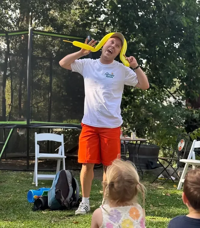 Entertainer using balloon props during a comedy performance at a children’s party