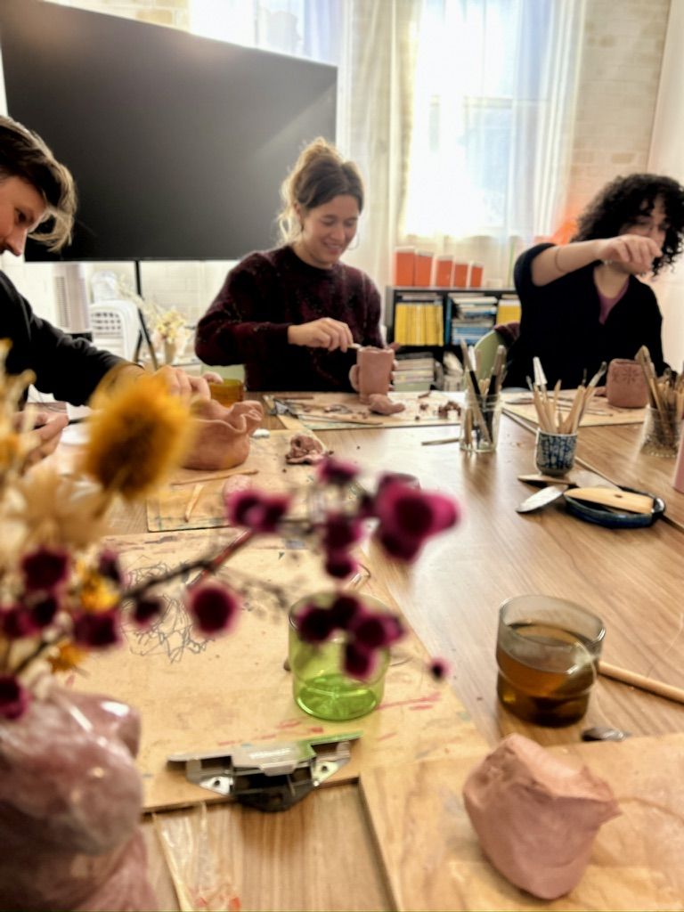 Participants smiling as they work on their pieces