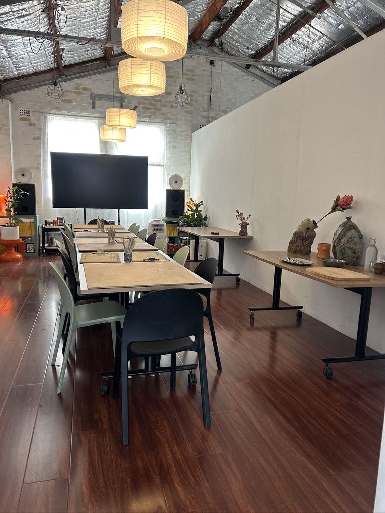 Workshop Space at Rikota Studios ready for a clay workshop, beautiful sunlit room with large table and plants set up for a clay class with tools and boards