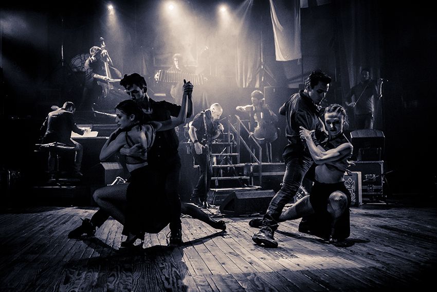 Four tango dancers perfuming in a bohemian cathedral, accompanied by a dark-lit seven-piece orchestra.