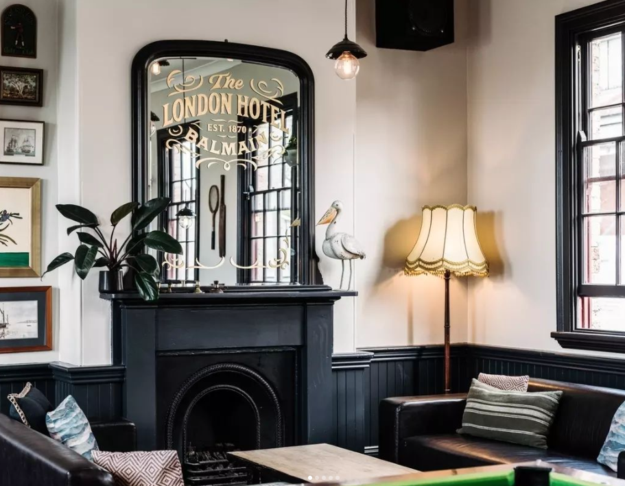 The upstairs room at The London Hotel Balmain. There are lounges next to the fireplace.