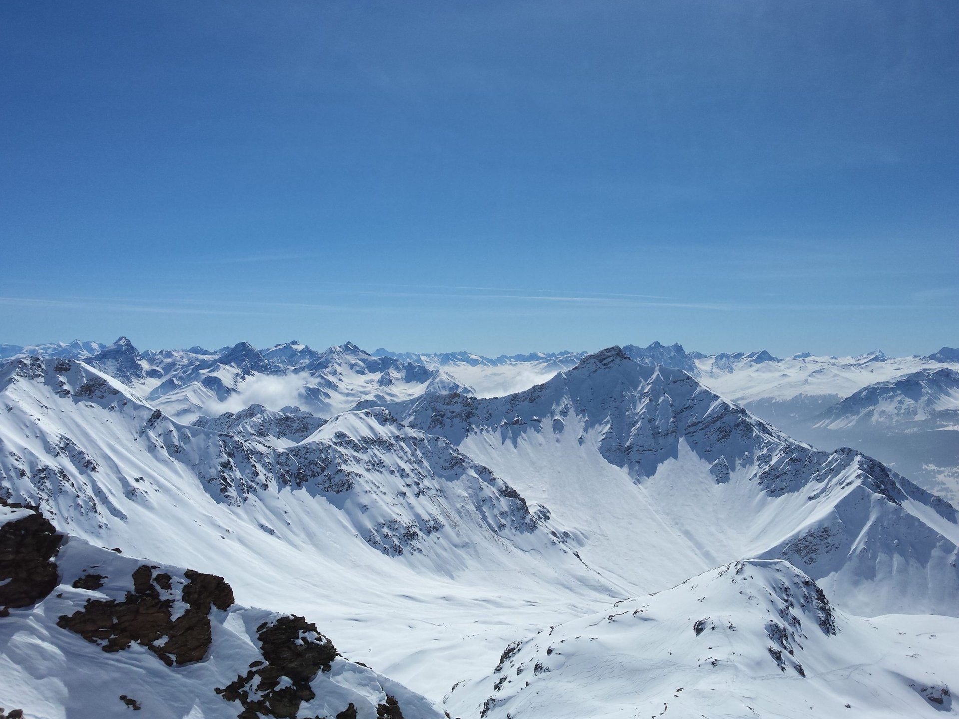 Schneebedeckte Alpenberge: Skifahren beim Wintercamping