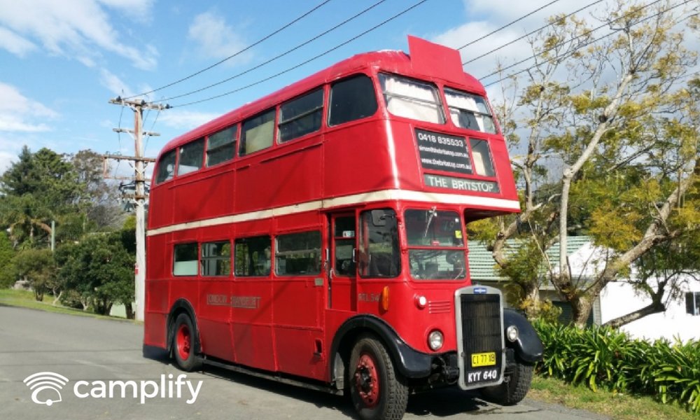 Couple relaxin' outside a retro caravan, enjoyin' the Aussie outback.