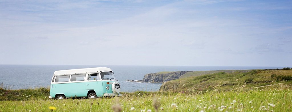 Campervan parked by a loch in the Scottish Highlands, wild camping adventure.