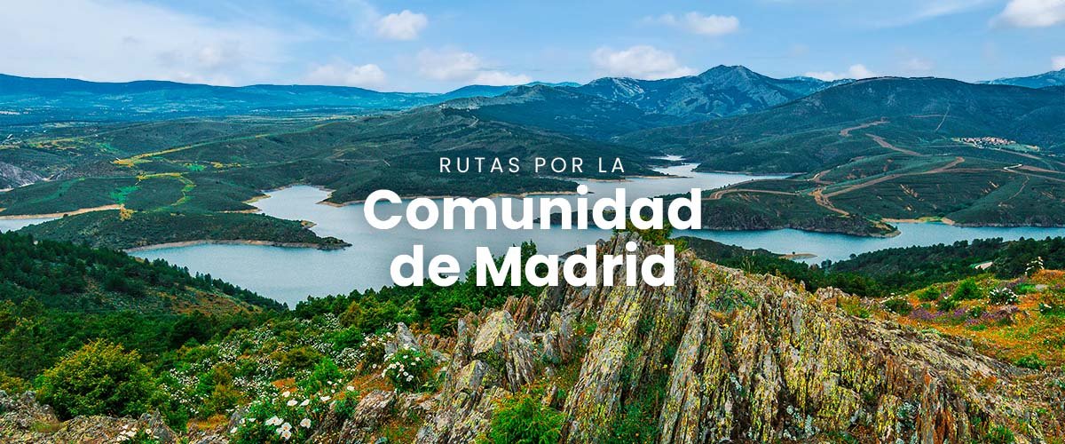 Autocaravana en ruta por la sierra de Madrid, con pueblos y montañas al fondo.