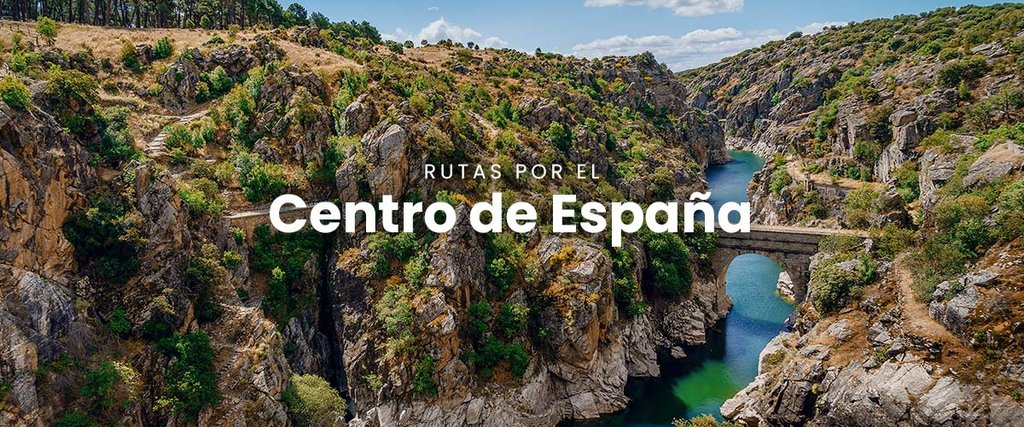 Autocaravana viajando por carretera rural en el centro de España. Paisaje soleado y montañoso.