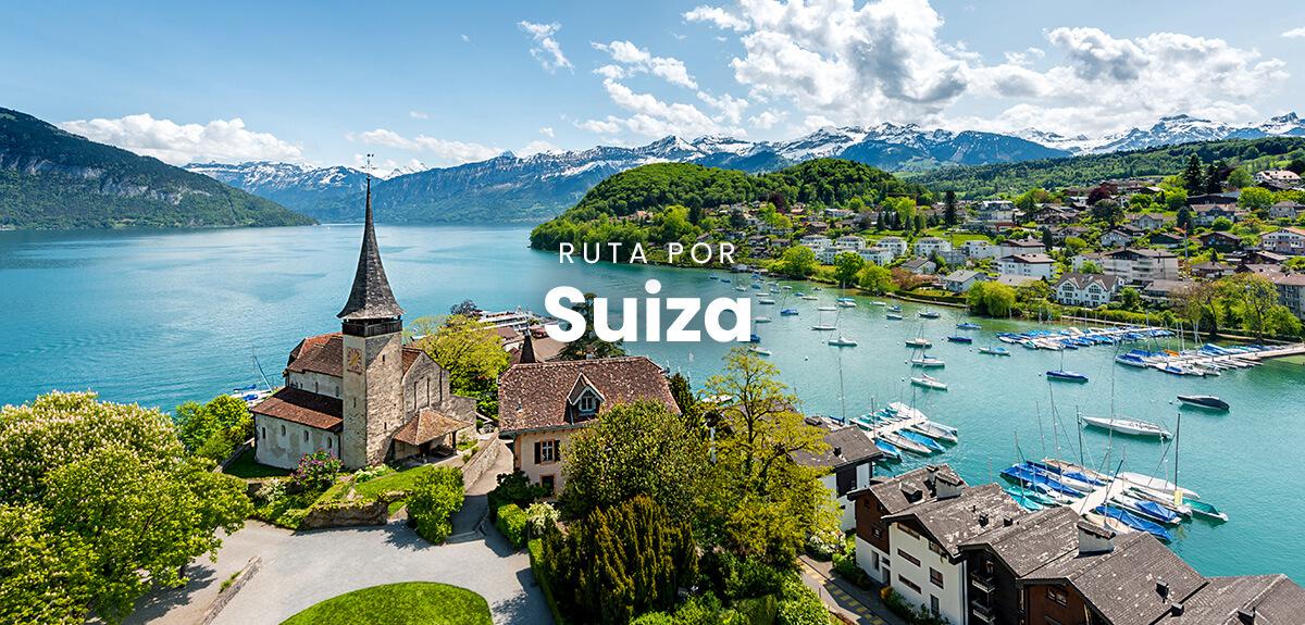 Autocaravana estacionada con vistas a montañas suizas. Paisaje alpino y cielo azul.