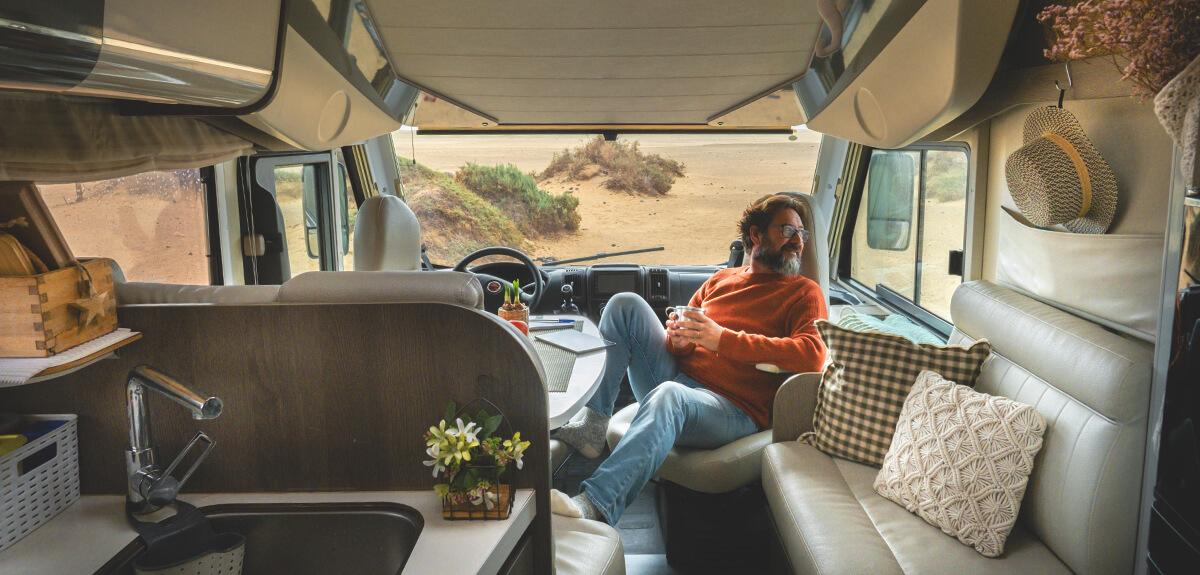 Autocaravana estacionada en un camping al atardecer, con familia disfrutando del aire libre.