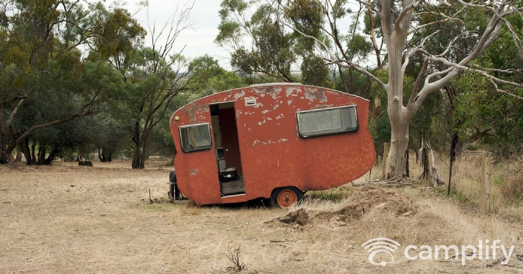Autocaravana antigua circulando por carretera costera con cielo nublado. Inspección de óxido.