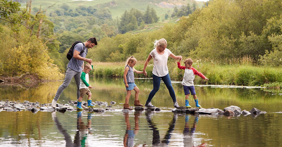 Family enjoying a camping holiday by the sea, caravan and awning pitched on a sunny holiday park.