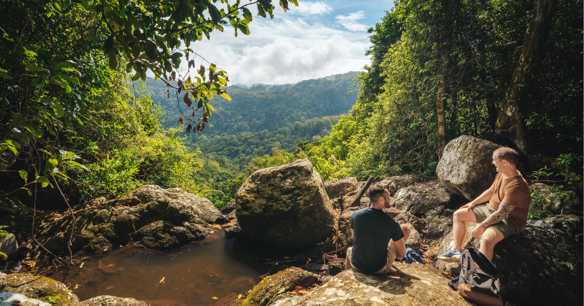 2 men sitting on a rock in Springbrook National Park QLD