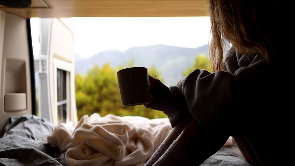 Autocaravana en la naturaleza con Madrid o Barcelona al fondo; escapada accesible y luminosa.