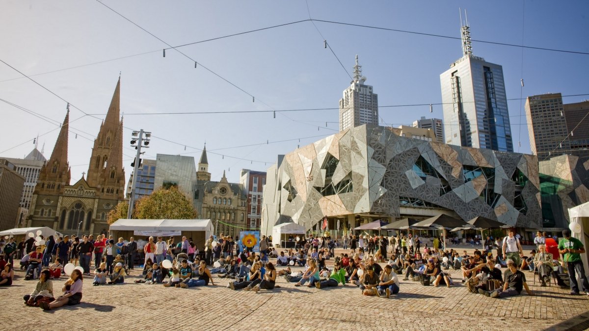 Melbourne skyline over the Yarra River at twilight, a vibrant and bustling city.