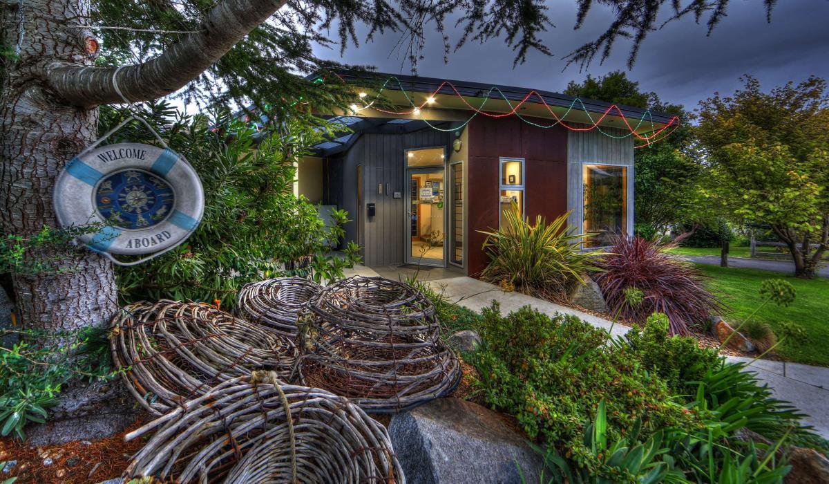 Family fun at a colourful holiday park, with cabins, a pool, and lush green lawns.