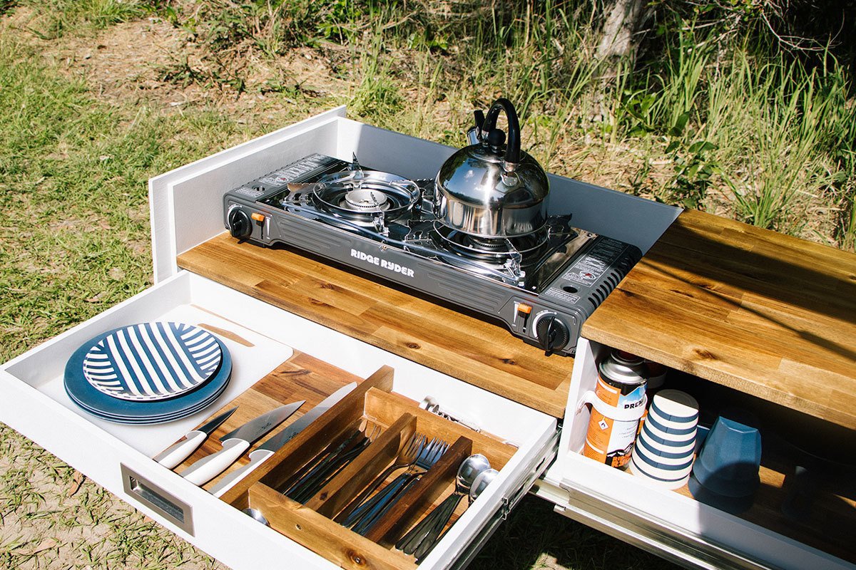 Campervan setup at a bush campsite, cookin' up a feed on a portable stove.
