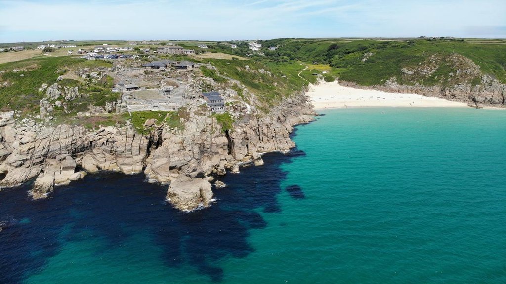 Campervan overlooking the Cornish coast on a sunny road trip, perfect for a van life adventure.