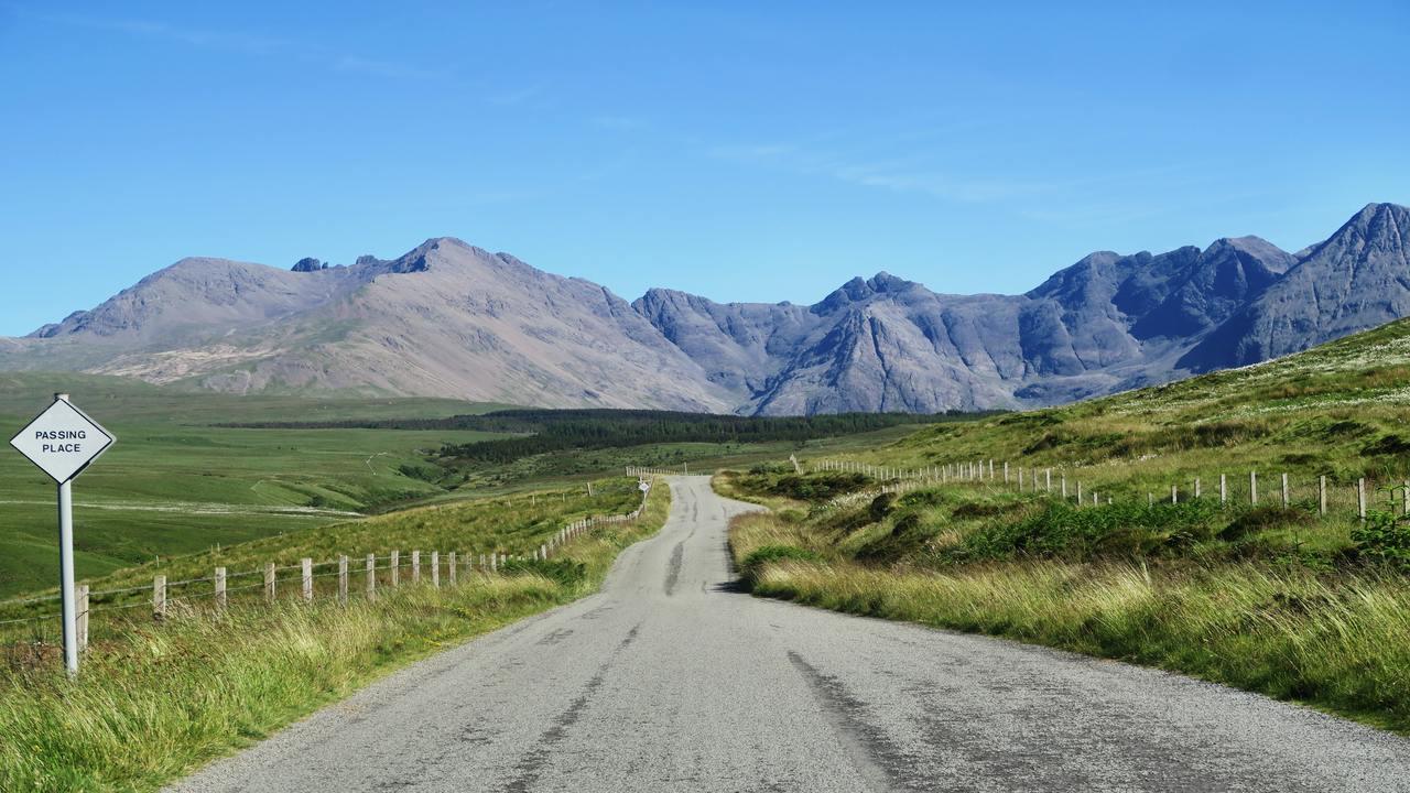 Motorhome touring the Scottish Highlands, with mountains and loch in the background.