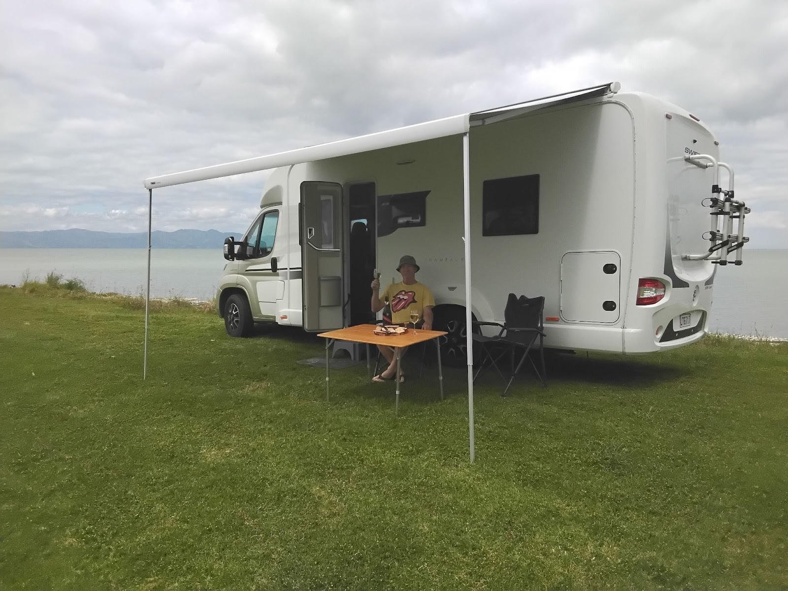 A man sitting under the awning of a motorhome