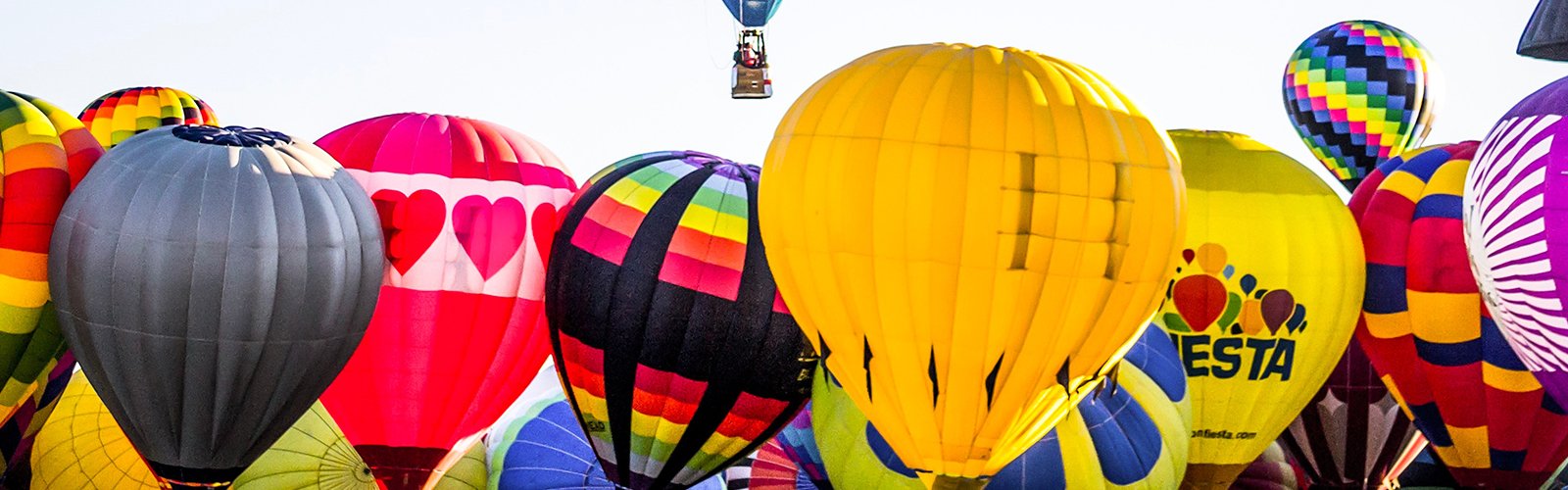 Motorhome parked at Bristol Balloon Fiesta, with hot air balloons ascending in the background.