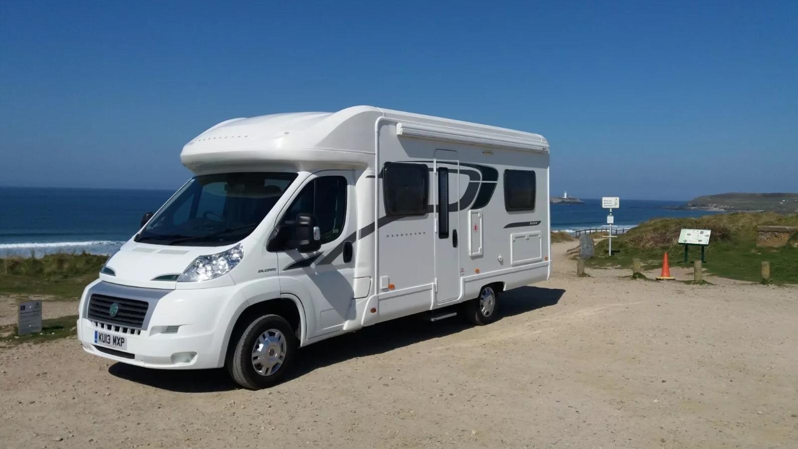 Caravan holiday: picturesque motorhome parked by a loch, promising scenic camping holidays and travel photography potential.