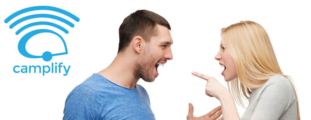 Couple laughing in a campsite, with a tent pitched amongst the gum trees.